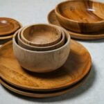 Stacked wooden bowls and plates in various sizes showcase natural wood grain, emphasizing eco-friendly dining aesthetics. Ideal for kitchen decor.