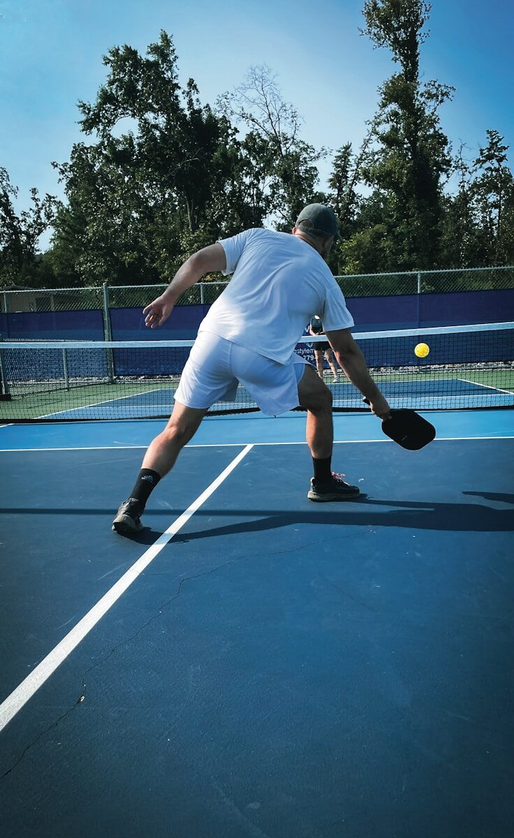 Man playing pickleball on a blue court