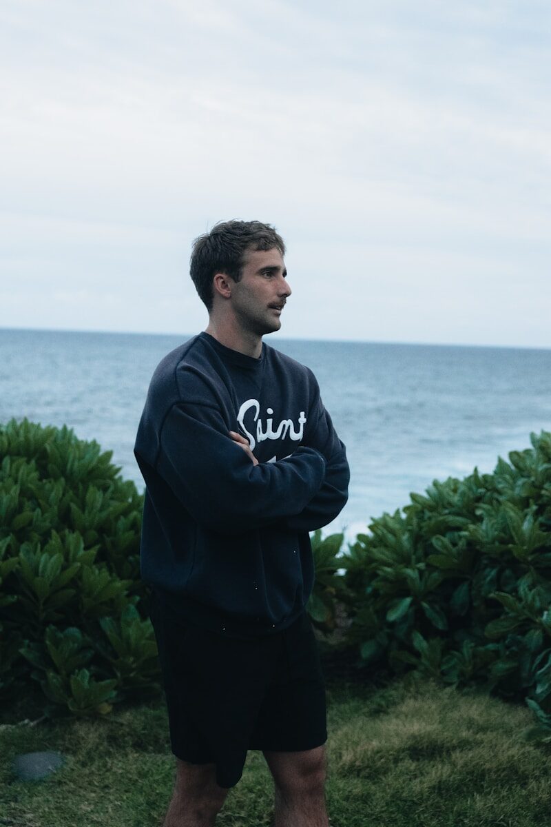 Man in sweatshirt looking out at the ocean